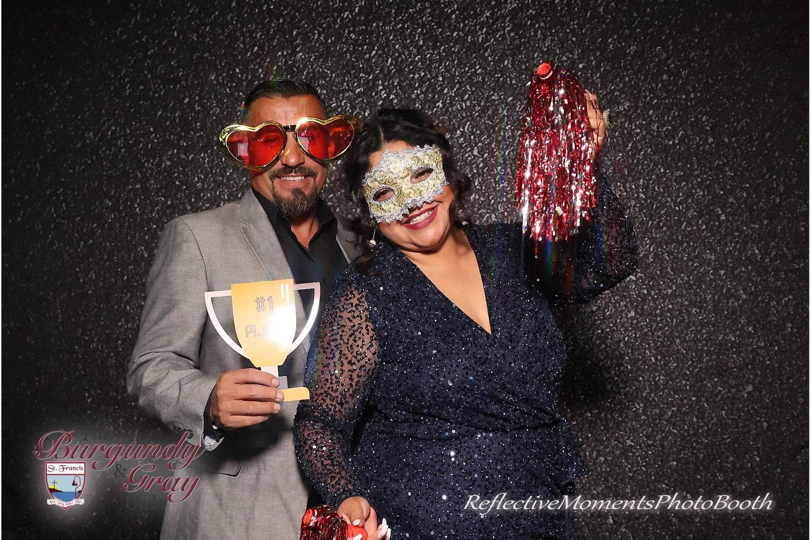 Guests posing at the mirror photo booth at the Burgundy and Grey Gala