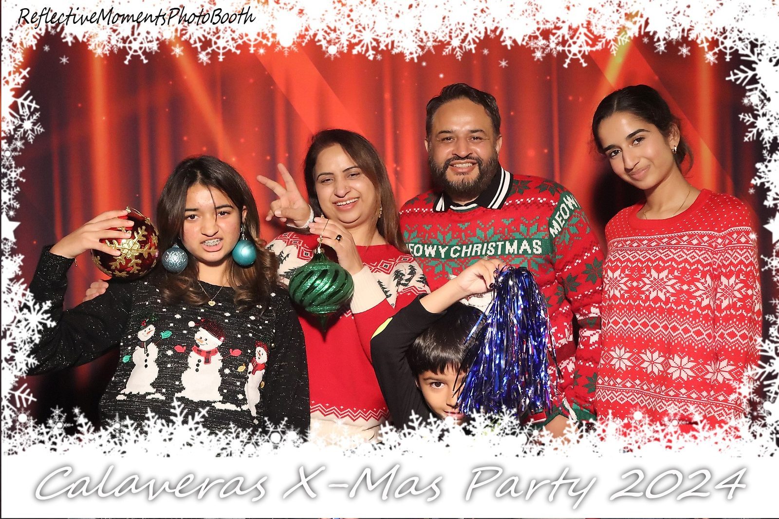 Group of coworkers posing at the mirror photo booth at the Christmas party