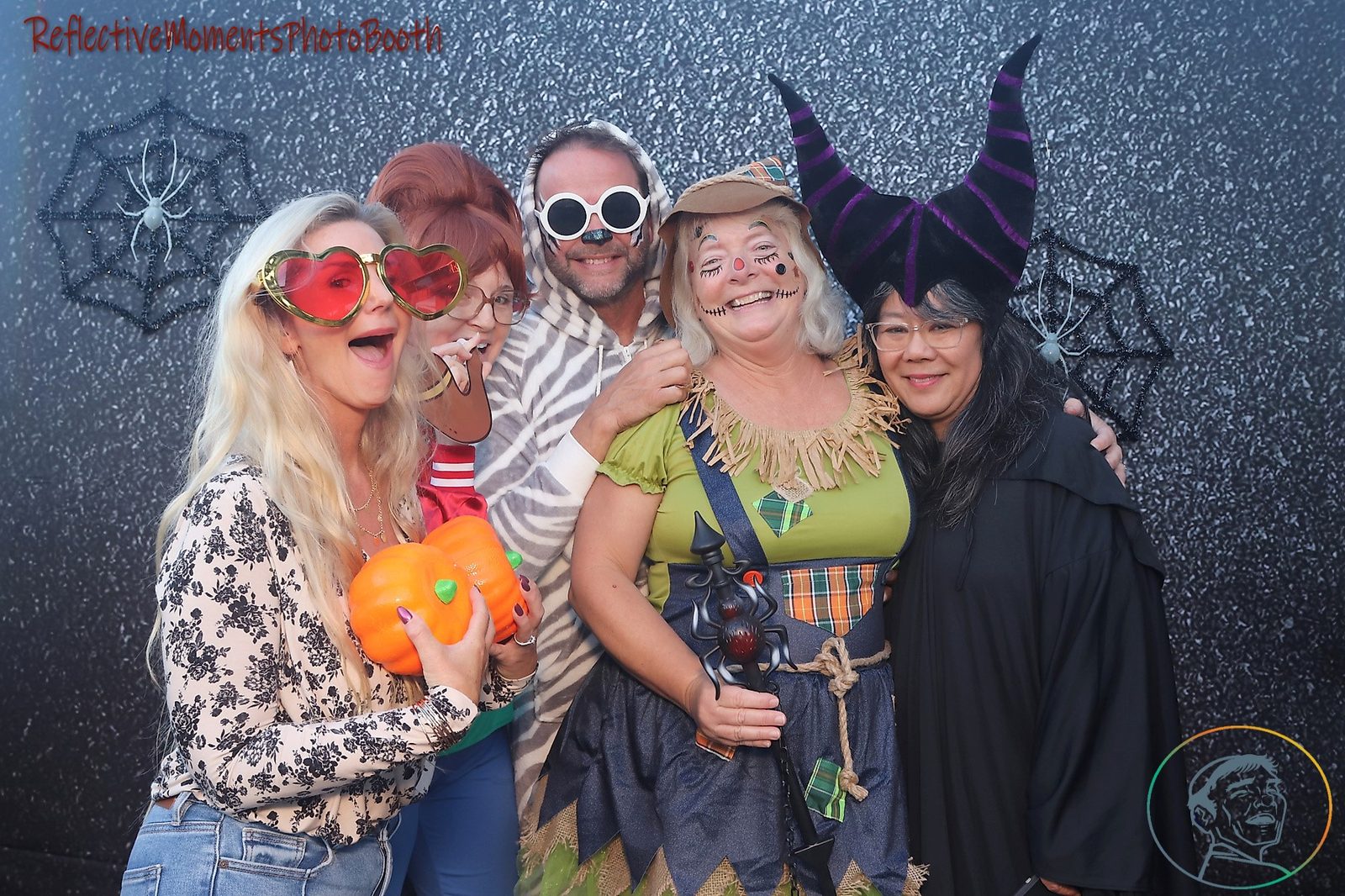 Group of friends in costume at the Halloween party photo booth
